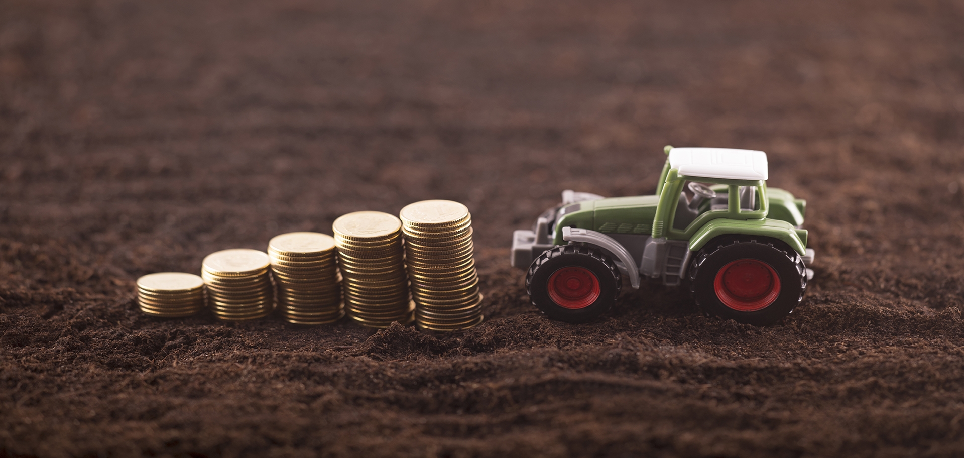 stacked coins with toy tractor
