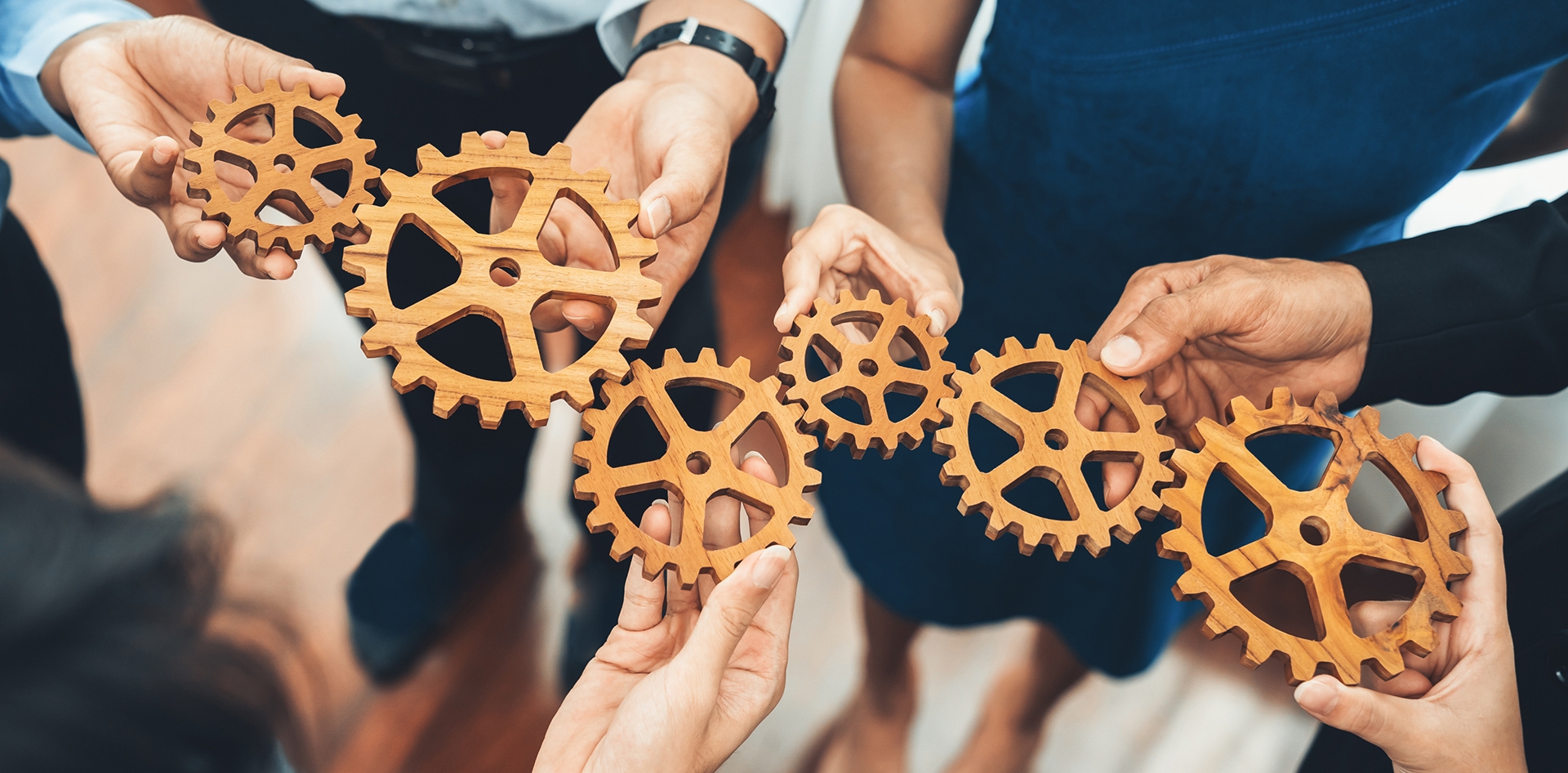 people holding wooden gears